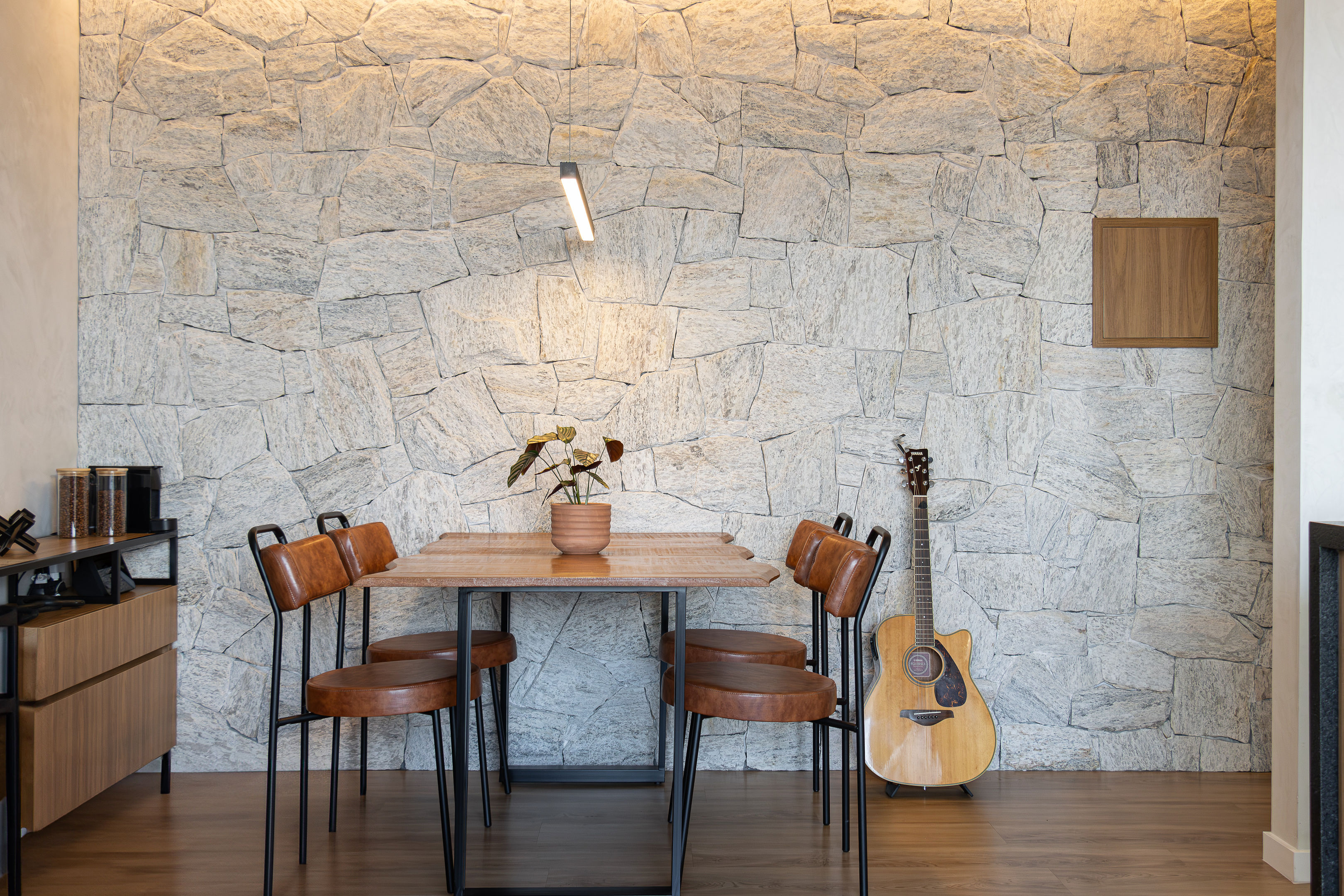 Apartamento Believe em SJC — sala de jantar com parede de pedra portuguesa