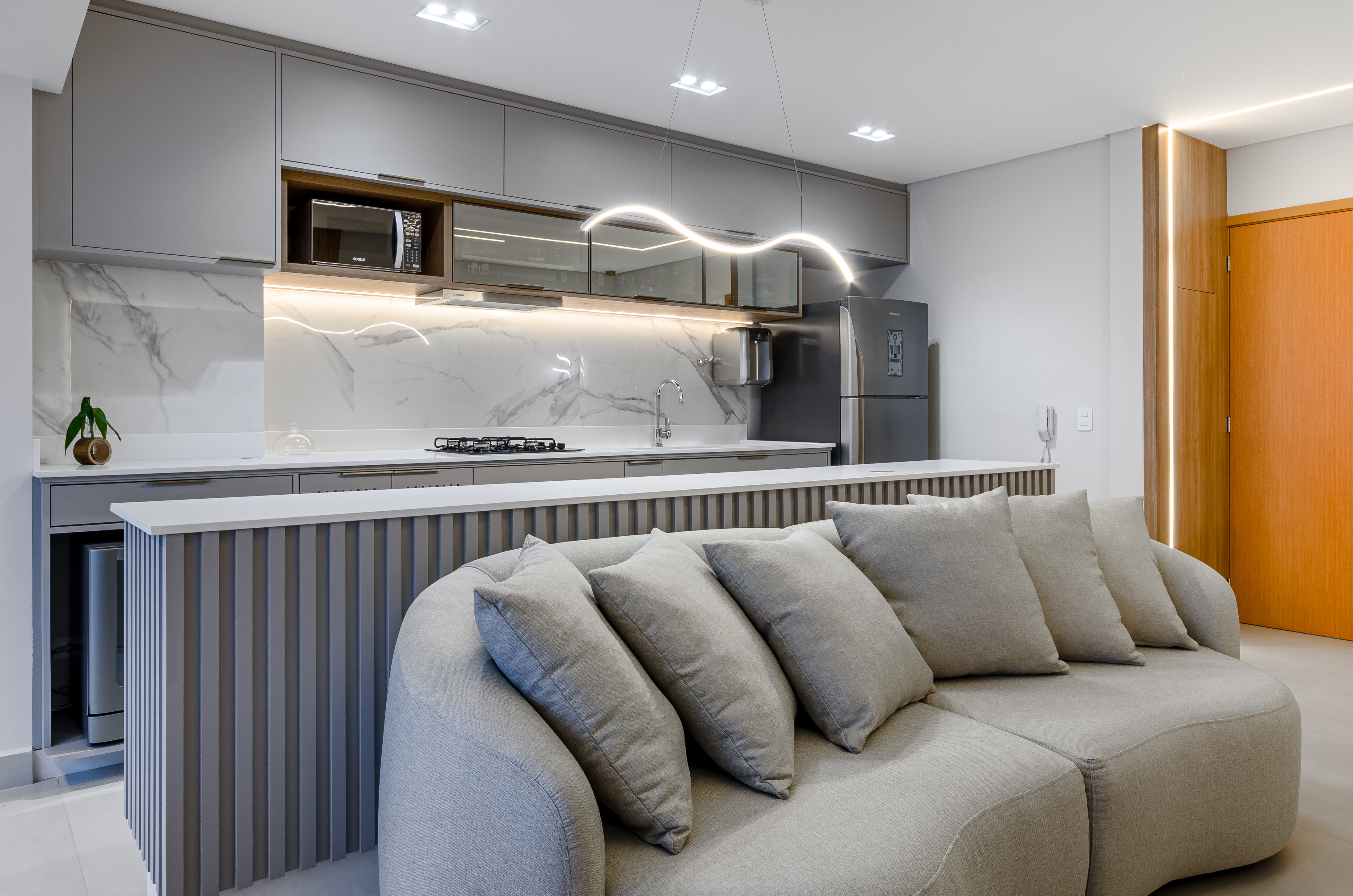 Cobertura Celebration Life em SJC — sala integrada com ilha canelada e vista da cidade