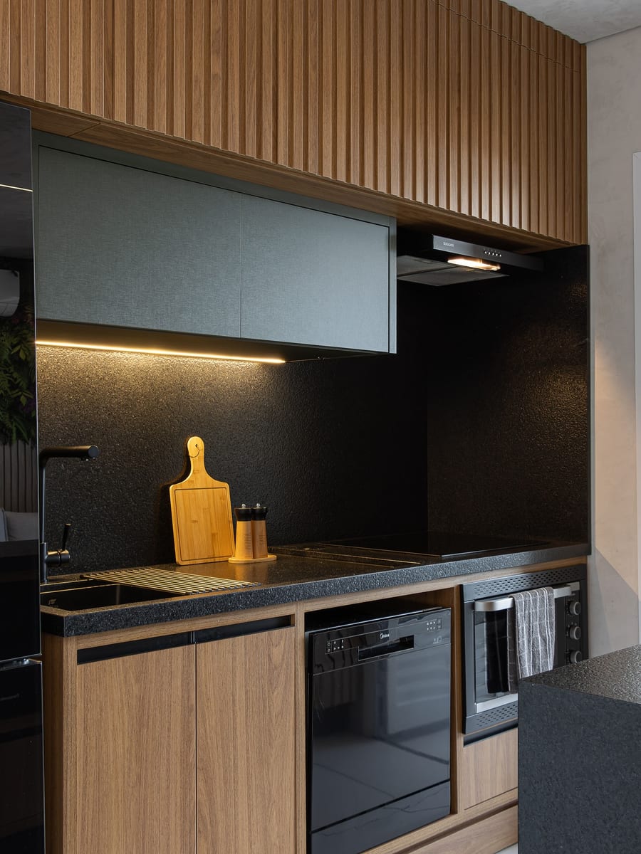 Cozinha preta com madeira em apartamento SJC